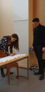 Minna Hölttä ja Perttu Jussila sinetöivät Vihreiden mukanaolon sopimuksessa. (Kuva: Jari Porraslampi)